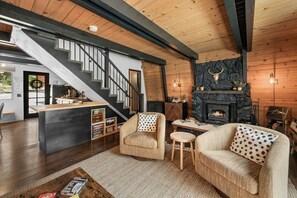 A modern interior with a staircase, a fireplace, and a cozy seating area.