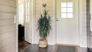 Ein Flur mit einer weißen Tür, einem Blumentopf und einem gefliesten Boden.
