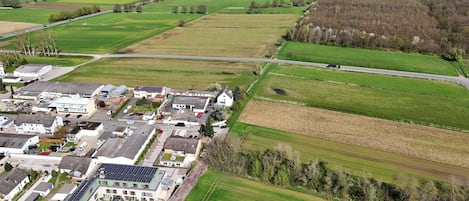 Vista aérea de una zona residencial con casas, paneles solares y campos verdes.