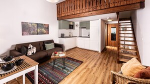 Un apartamento moderno con zona de estar tipo loft, una cocina y una escalera.