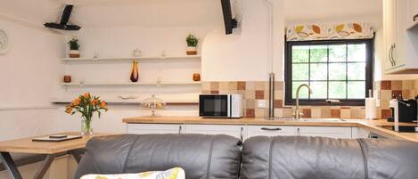 A modern kitchen with a microwave, stove, and a window with a view.