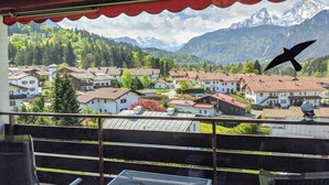 Un balcon avec vue sur un village et des montagnes.