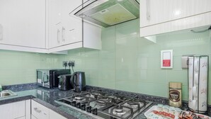 A kitchen with a gas stove, a coffee maker, and a tray of snacks. - Luxury Mayflower Apartment, Central City Centre, Newly Refurbished (Plymouth)
