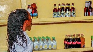 Ein Regal mit verschiedenen abgefüllten Getränken, darunter Wasser, Limonaden und alkoholische Getränke.