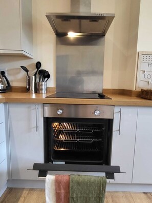 Kitchen features an oven with glass door and stainless steel range hood.