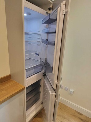 Kitchen features a refrigerator with separate freezer and main compartments.