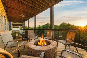 A deck with a fire pit, outdoor furniture, and a view of the sunset. - Indoor Pool! Lake Access! Hot Tub! (Branson)