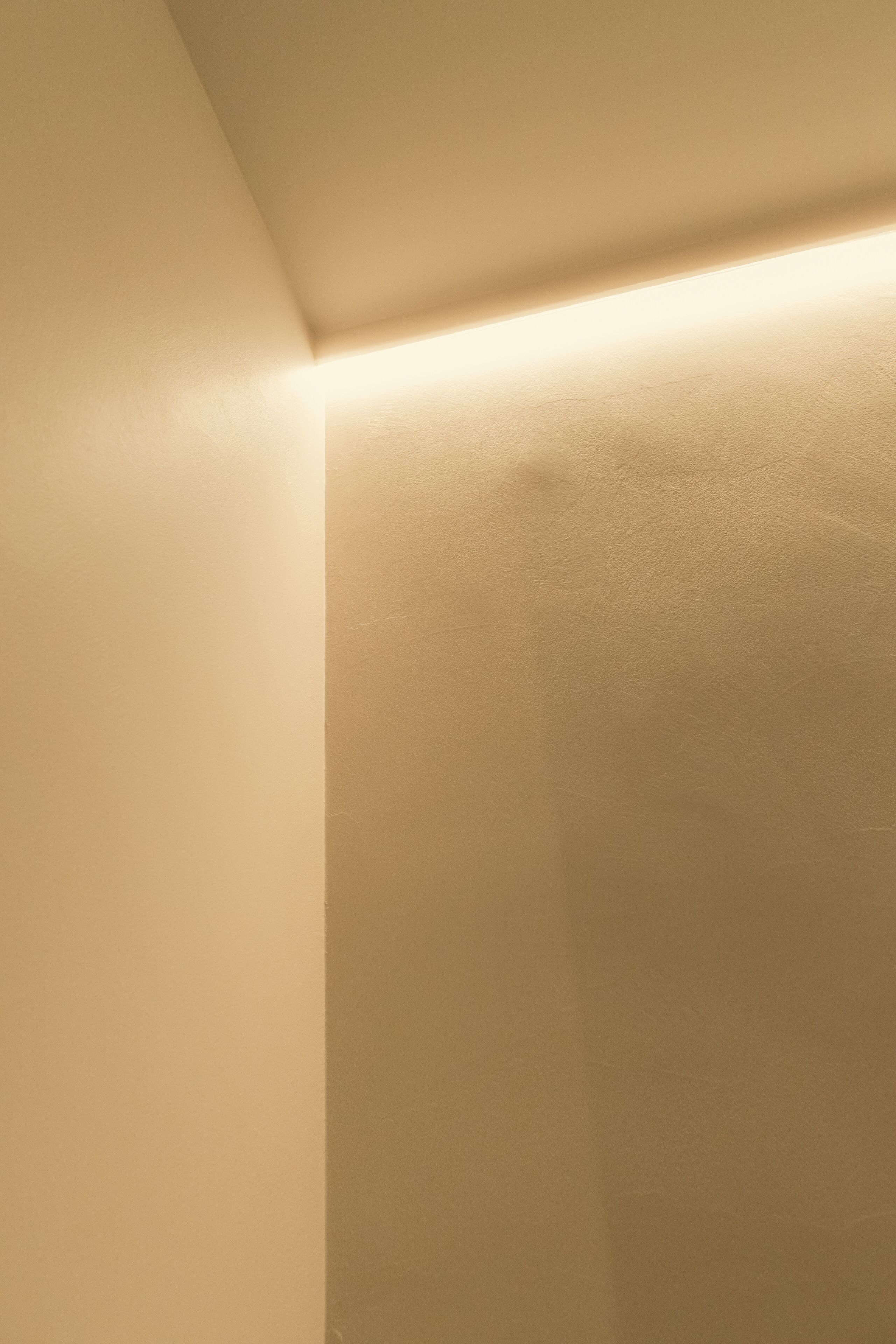 A corner of a room with a light fixture casting a warm glow.