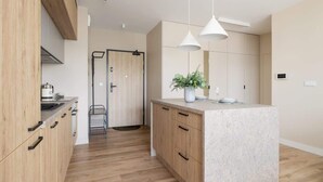 Une cuisine moderne avec des meubles en bois, un îlot central et des luminaires suspendus.