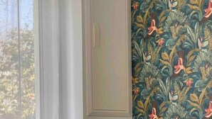 Une chambre d’hôtel avec un lit, deux oreillers et une fenêtre avec des rideaux.