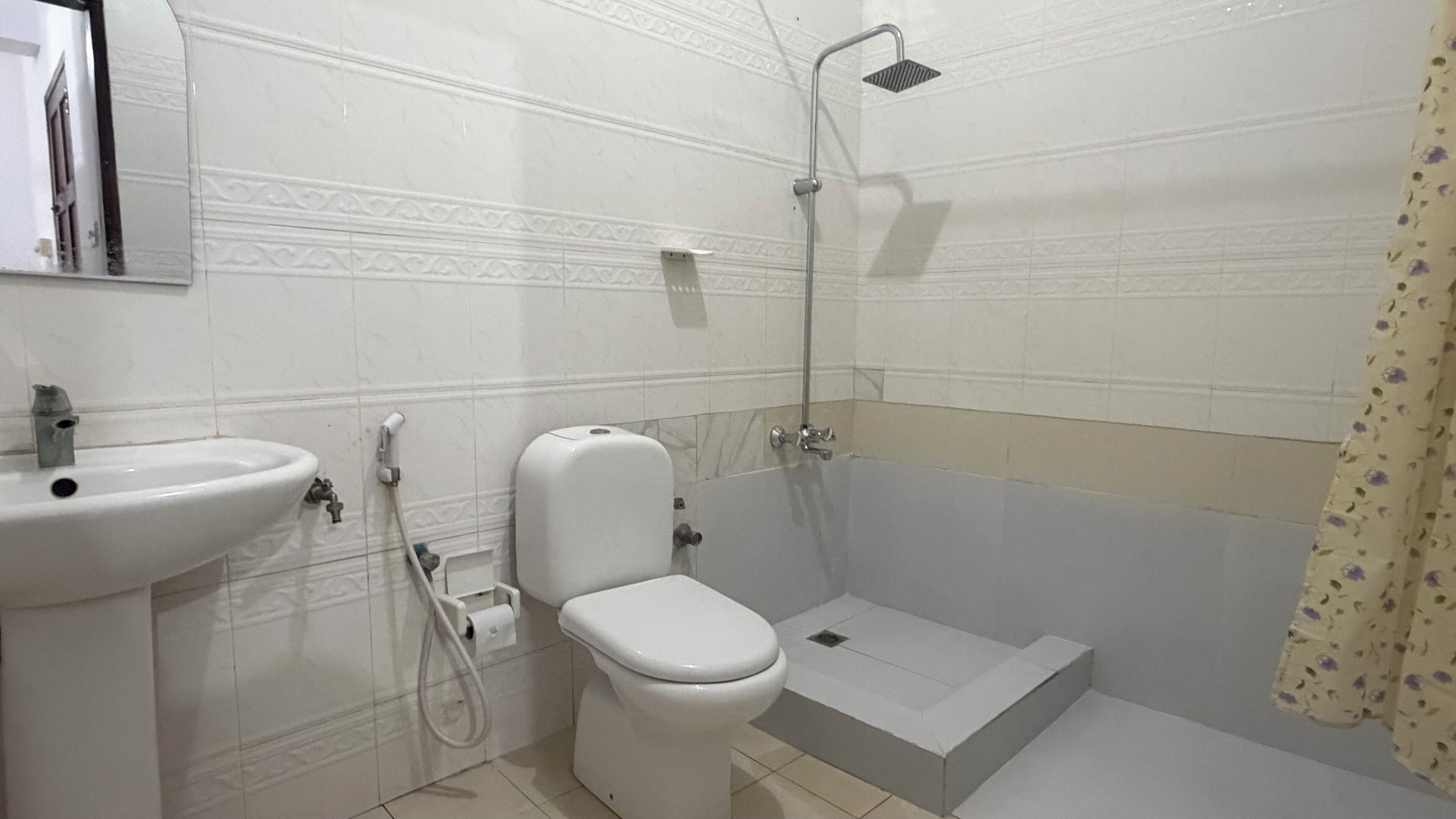 A bathroom with a toilet, sink, and shower.