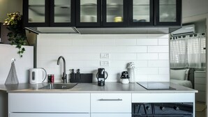 Een moderne keuken met witte kastjes, een zwart aanrecht en een inbouwoven.