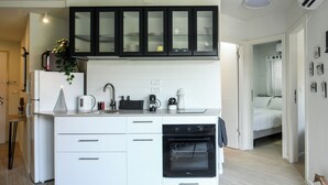 Een moderne keuken met witte kastjes, een ingebouwde oven en een zwarte afzuigkap.
