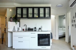 Eine moderne Küche mit weißen Schränken, einem eingebauten Backofen und einer schwarzen Dunstabzugshaube.