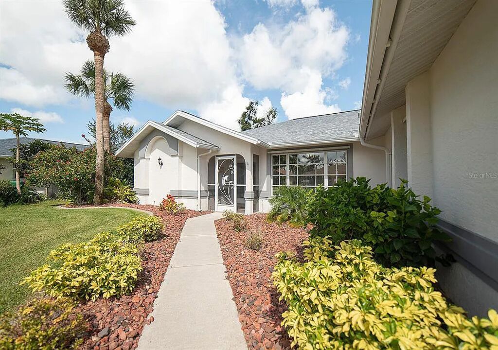 A single-story house with a front entrance, a covered porch, and a pathway leading to the door.