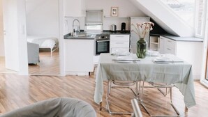 Eine moderne Küche mit Essbereich, weißen Schränken und einem Oberlicht.