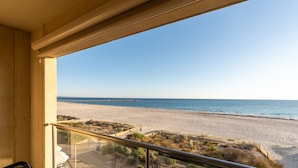 A balcony with a view of a beach and a pier.