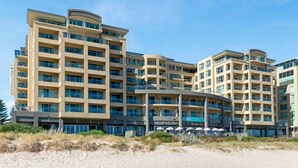 A multi-story hotel with a modern architectural design, featuring balconies and large windows.