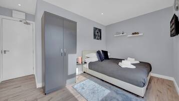 A bedroom with a bed, bedside table, and a wardrobe.