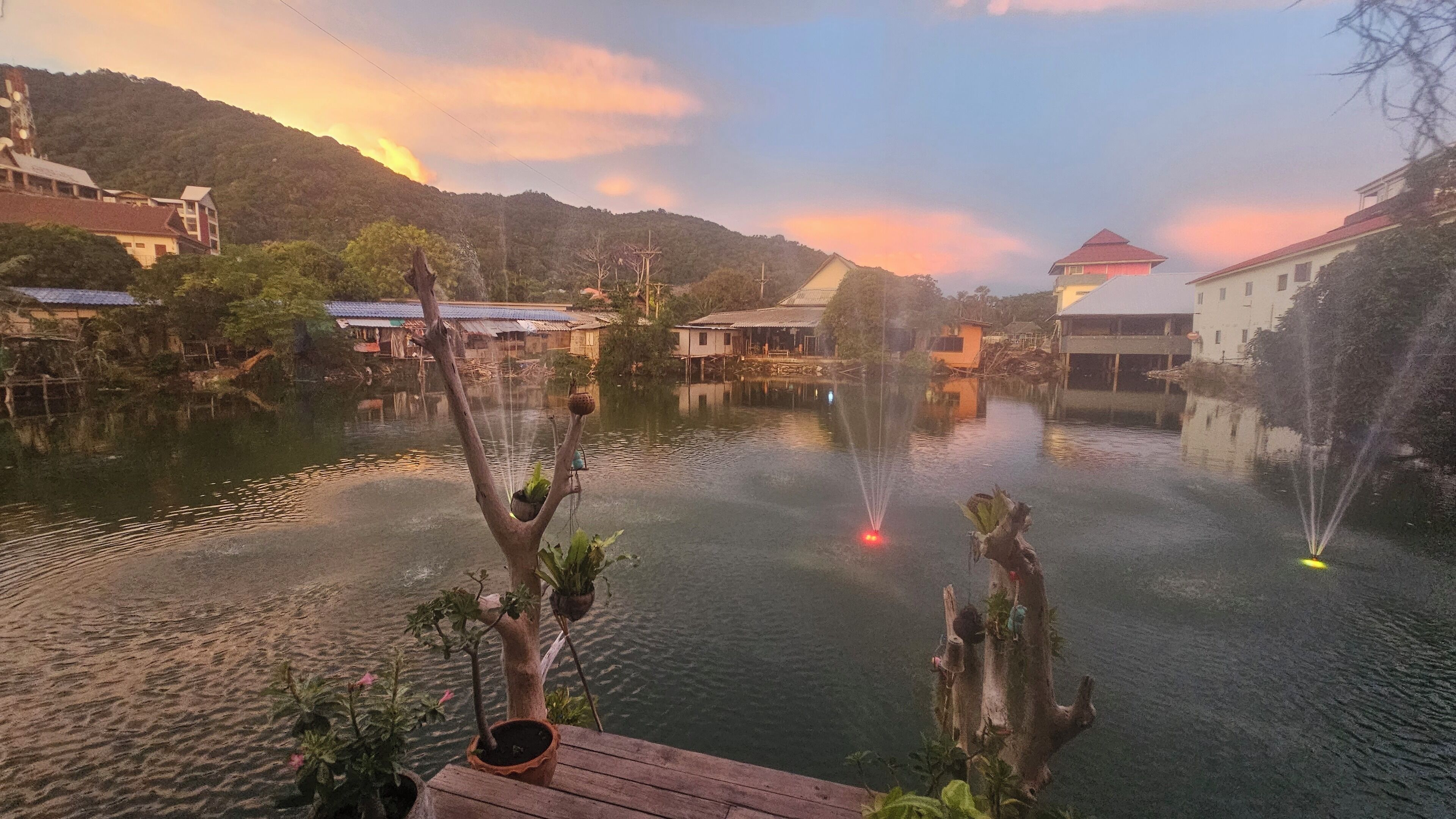 A serene lakeside view with traditional buildings and a wooden dock.