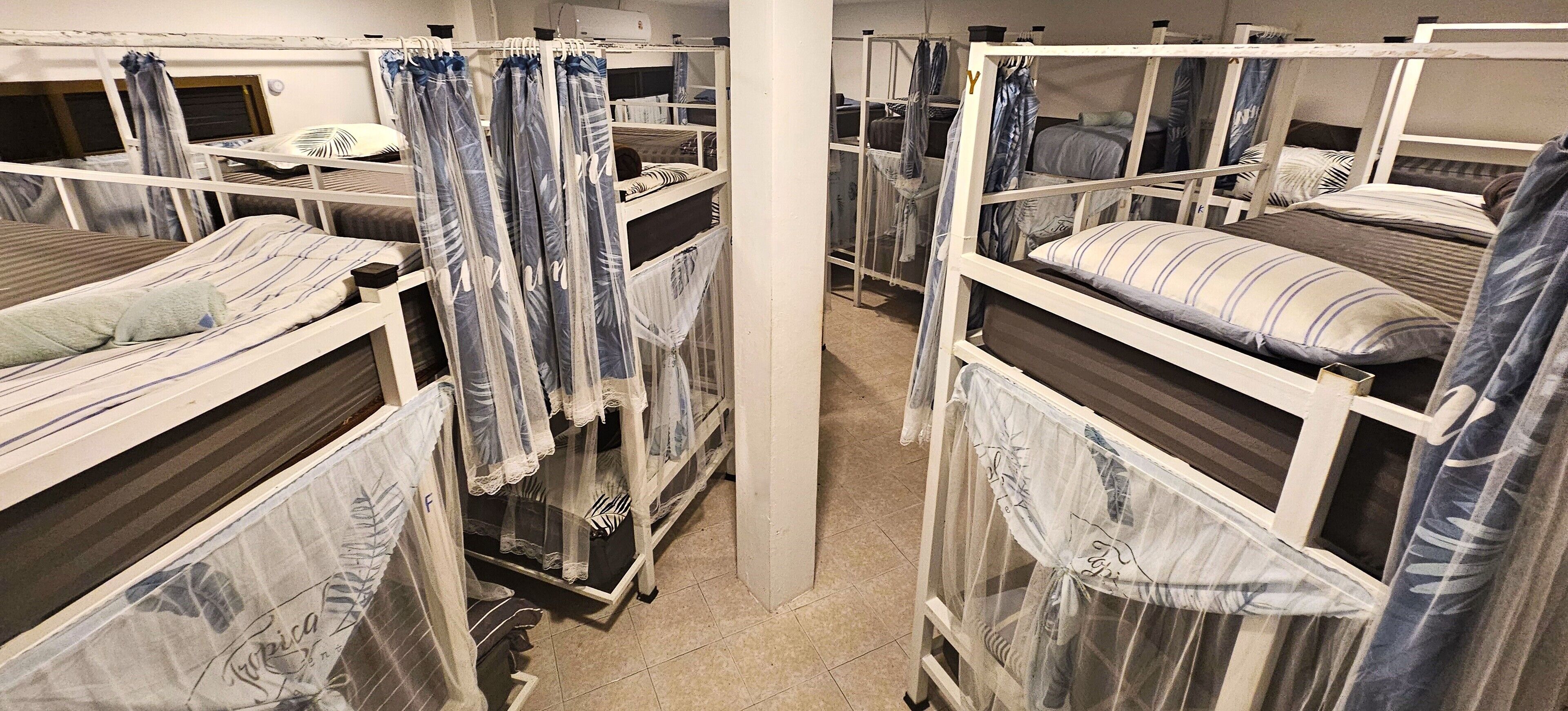 A room with bunk beds, each with a canopy.