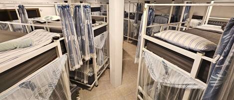 A room with bunk beds, each with a canopy.