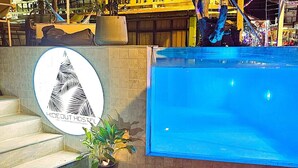A pool area with a sign for 'Hideout Hostel' and steps leading up to it. - Hideout Hostel (Ko Pha-ngan)