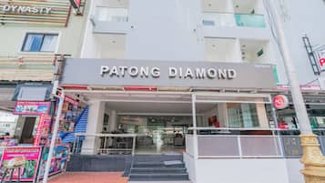The exterior of the Patong Diamond hotel with a clear entrance, a staircase leading up to the entrance, and a visible signboard.