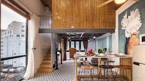 Una cocina moderna con comedor, detalles de madera y un amplio ventanal con vistas a un paisaje urbano.