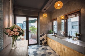 A modern kitchen with a large window, a wooden cabinet, and a hexagonal tile floor.