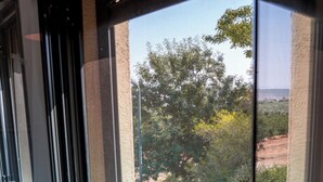 A window with a view of a swimming pool, surrounded by greenery and trees. - Artistic Vac Villa w pool by Sea N' Rent (Rishon LeTsiyon)