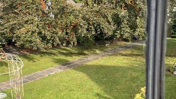 A garden with a stone pathway, a metal sculpture, and various plants.