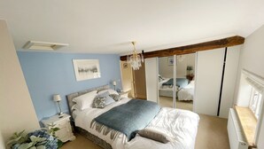 A bedroom with a bed, bedside tables, a mirror, a chandelier, and a radiator. - Eagle House- Award Winning B&B and Apartment (Stafford)