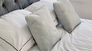 A bed with a tufted headboard and two pillows. - Modern Room in Centrally Located- Room 4 (London)