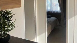 A hotel room with a bed, a plant, and a sign that reads "our guest". - Lovely 2-bed Cabin in Birchington (Birchington)