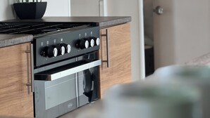 A modern kitchen with a built-in oven and a black stovetop. - Lovely 2-bed Cabin in Birchington (Birchington)