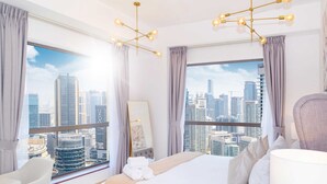 Ein modernes Hotelzimmer mit einem großen Bett, einem Schminktisch und Blick auf die Stadt.