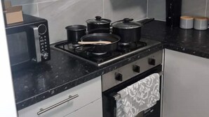 Una cucina dotata di fornello, forno, microonde e pensili.