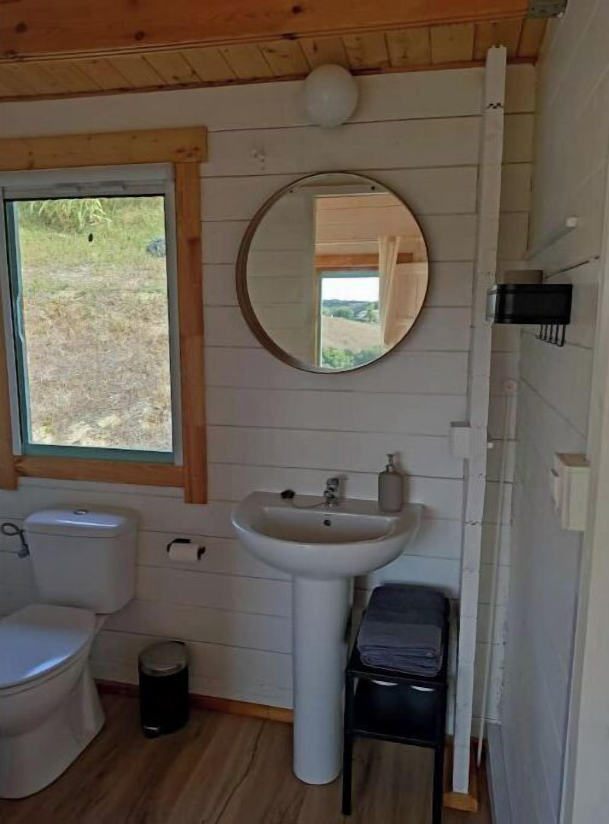 Une petite salle de bain comprenant des toilettes, un lavabo et un miroir.
