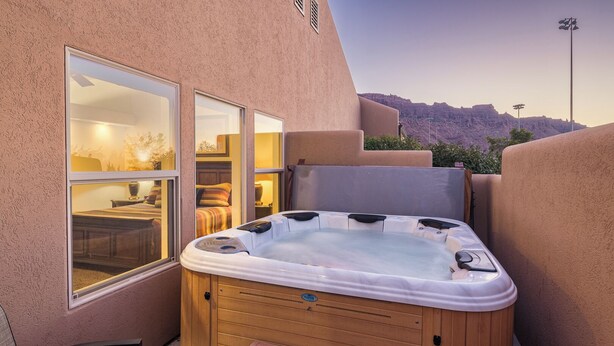 Un jacuzzi en un entorno exterior con vistas a un paisaje montañoso.