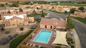 Zona residencial con varias casas, una piscina y montañas al fondo.
