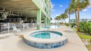 A swimming pool with lounge chairs, a covered parking area, and palm trees. - Best View in Ft Morgan | Relaxing Retreat w Pool - Boat Slips + Hot Tub (Gulf Shores)