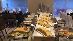 Un bufé con diversos alimentos, incluyendo frutas y pasteles.