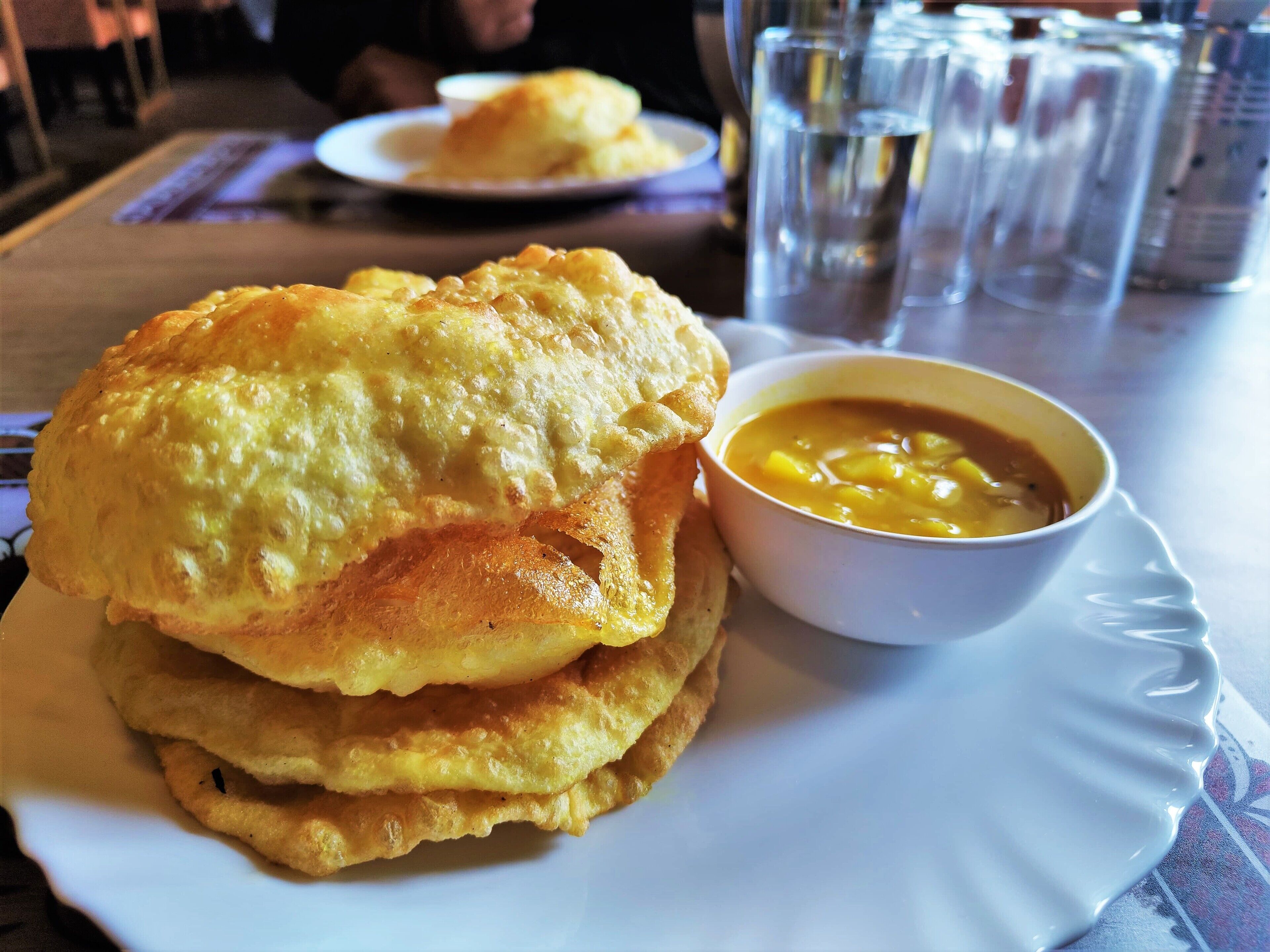 A plate with two fried items and a bowl of soup.