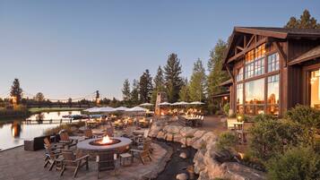 An outdoor patio area with a fire pit, seating, and a view of a lake.