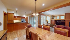 Una cocina amplia con gabinetes de madera, una isla central e iluminación colgante.