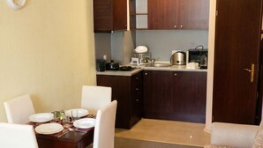 A compact living space with a dining area, kitchenette, and a sofa. - Mountain Paradise 2 - Cosy Mountain View Apartment - 200mbps Wifi (Bansko)