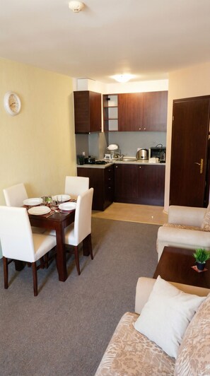 A compact living space with a dining area, kitchenette, and a sofa. - Mountain Paradise 2 - Cosy Mountain View Apartment - 200mbps Wifi (Bansko)
