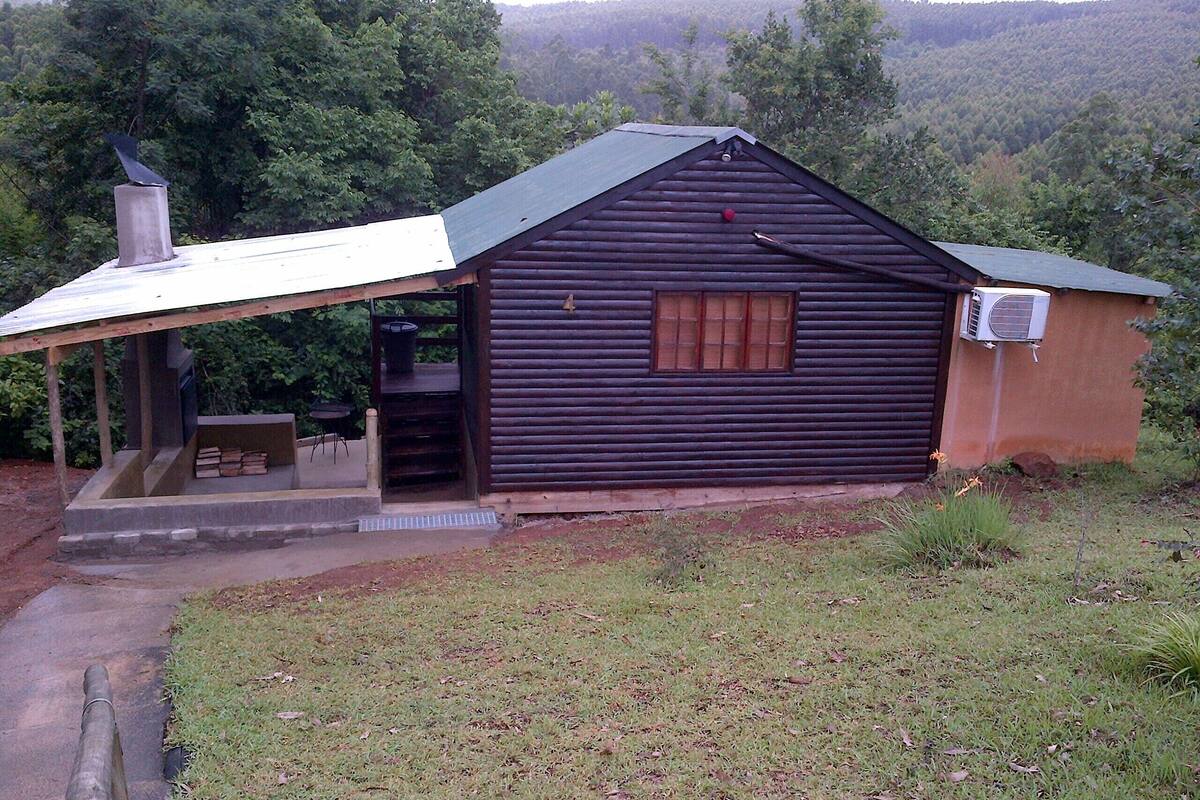 A small wooden cabin with a porch, a chimney, and a window.