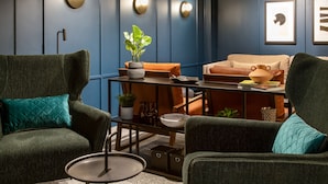 Una sala de estar moderna con un sofá, sillones, una mesa de centro y una mesa de comedor.